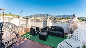 A rooftop terrace with outdoor furniture, a green mat, and a view of mountains. - Holiday Home 'The Palm House' with Mountain View, Wi-Fi and Air Conditioning (Las Lagunas de Mijas)