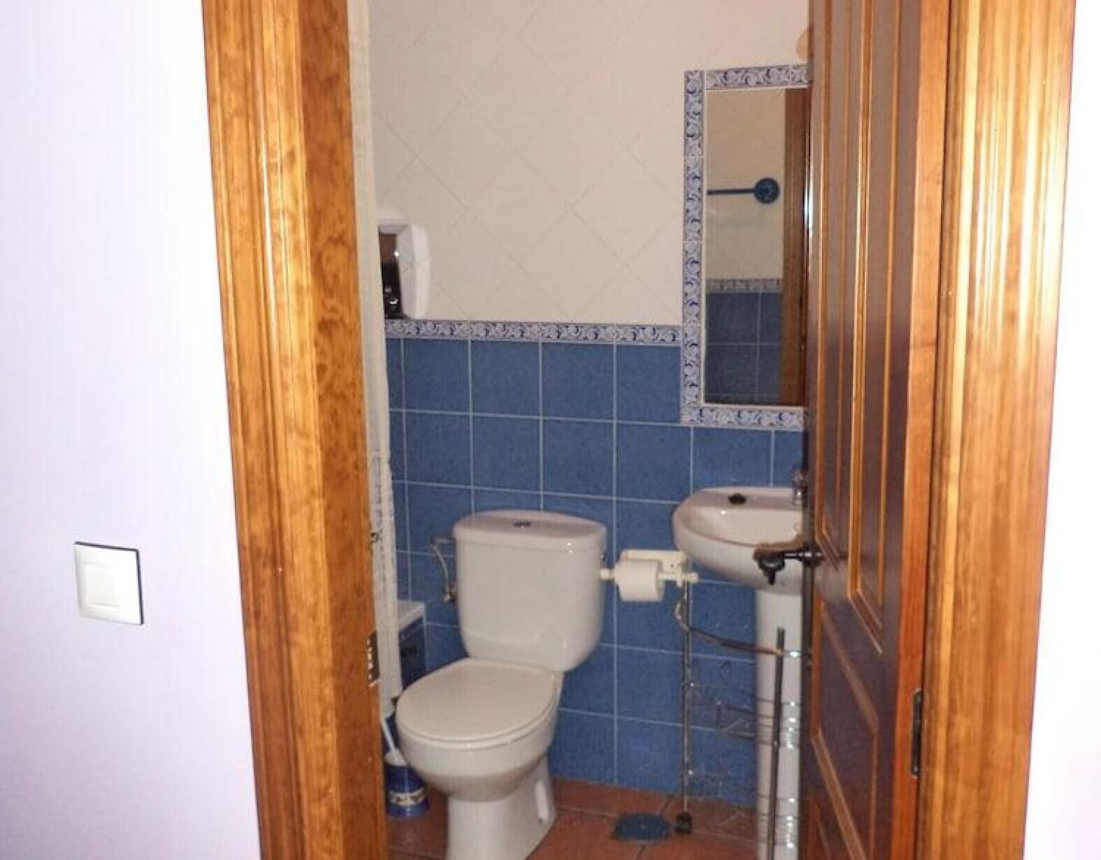Un baño con inodoro, lavabo y espejo.