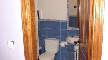 Un baño con inodoro, lavabo y espejo.