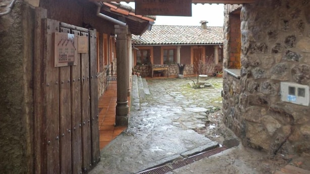A stone building with a wooden door and a tiled roof.