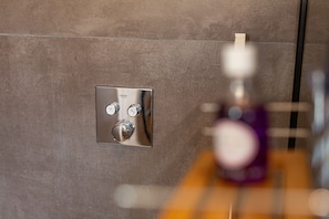 A bathroom with a modern shower control panel on a textured wall. - Apartment "Casa Zen" with Private Terrace, Private Garden and Wi-Fi (Vernosc-lès-Annonay)