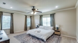 A bedroom with a large bed, a ceiling fan, two bedside tables with lamps, and a rug. - NEW! Charming Retreat Near Dickie's Arena – Cozy & Stylish Fort Worth Getaway (Fort Worth)