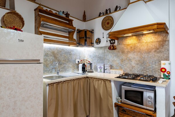 A kitchen with a refrigerator, stove, microwave, sink, and wooden cabinets.