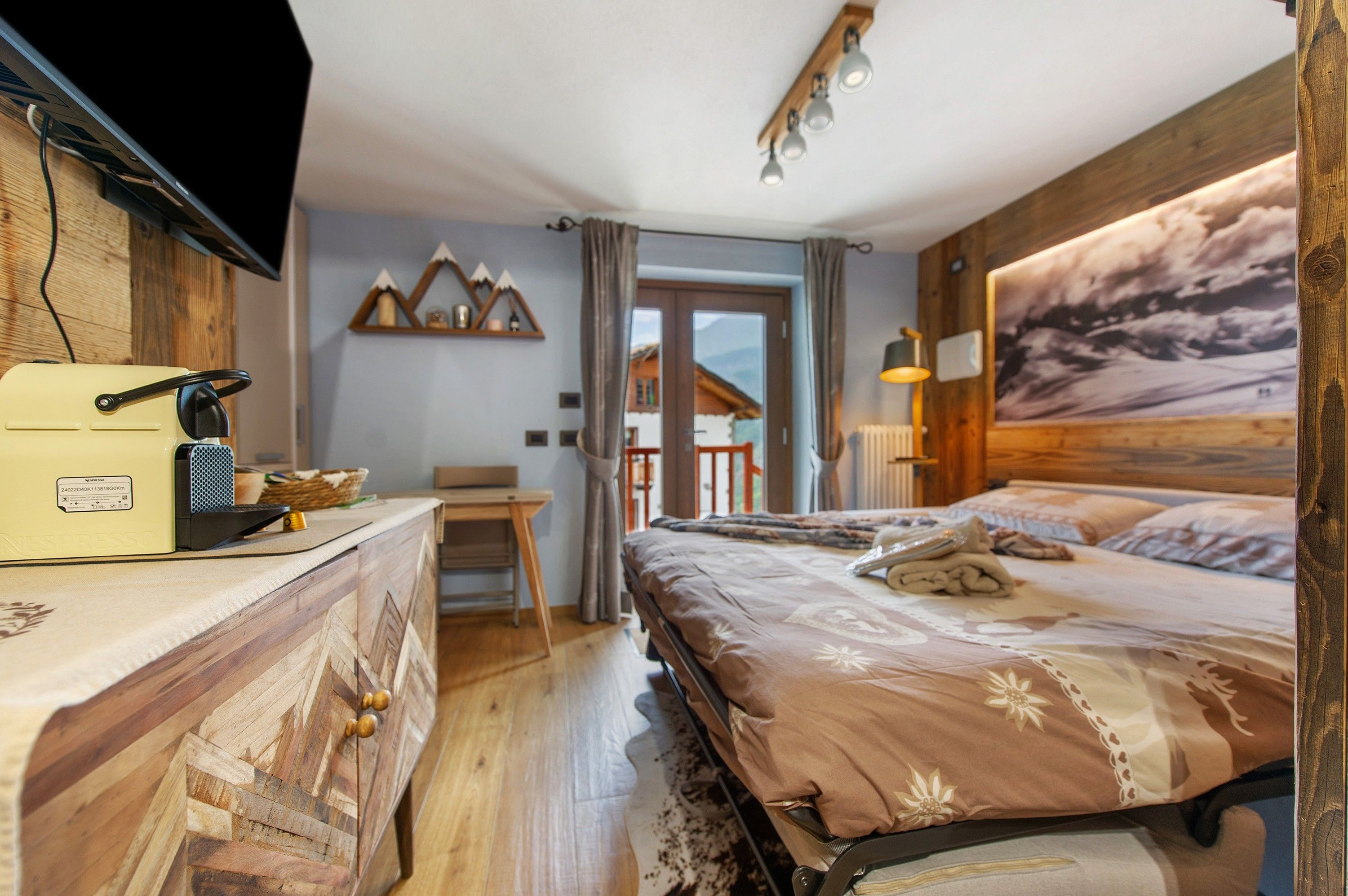 Een slaapkamer met een bed, bureau, stoel en een televisie.