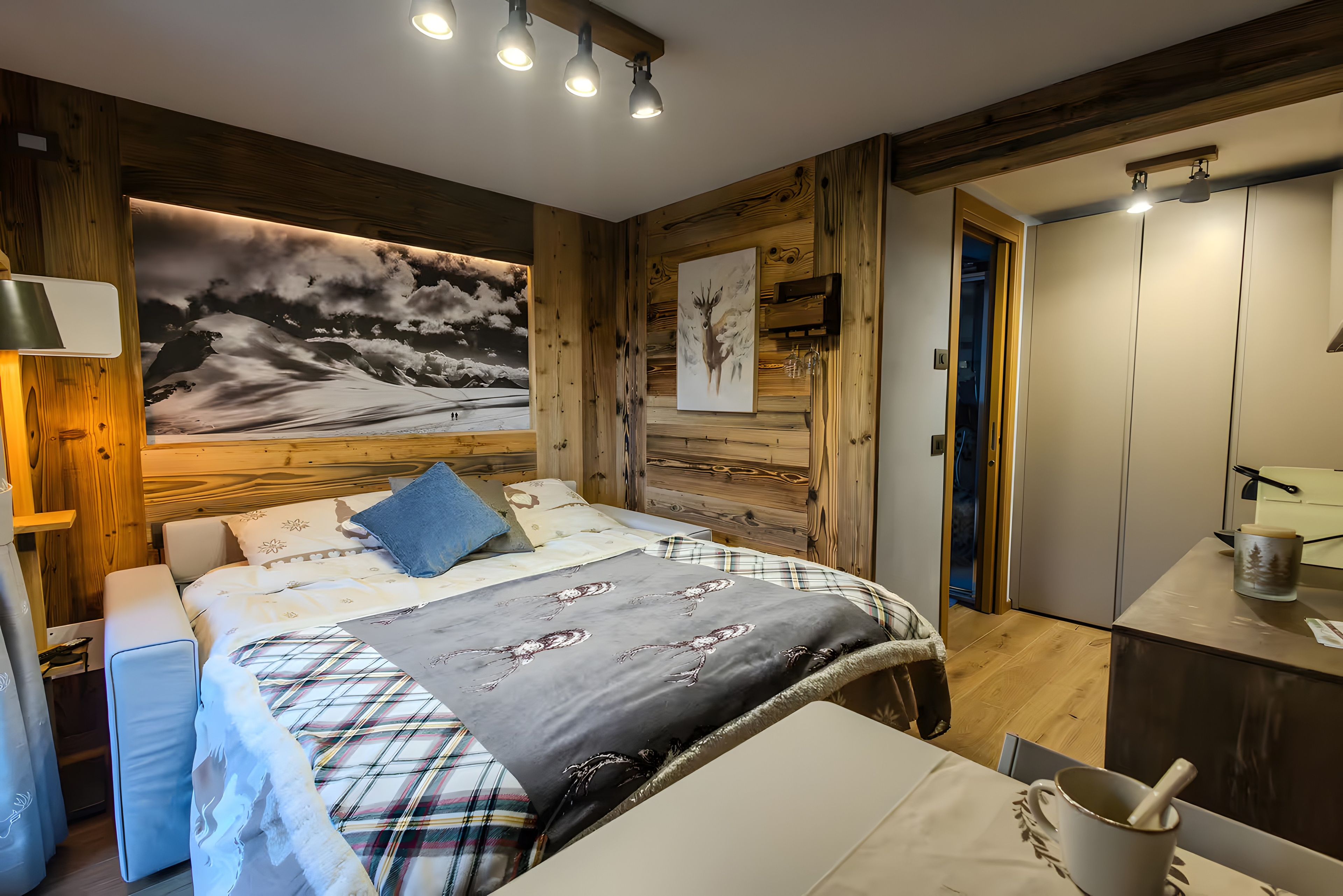 Une chambre à coucher avec un lit, une table de chevet, un tableau et un mur en bois.