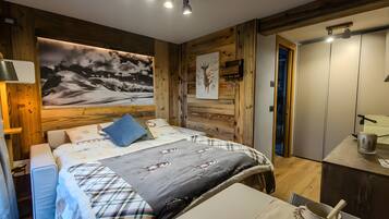 Une chambre à coucher avec un lit, une table de chevet, un tableau et un mur en bois.