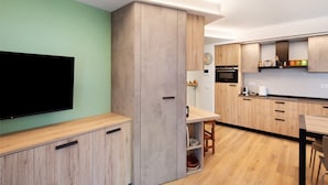 Una cocina moderna con armarios de madera, un televisor de pantalla plana y un comedor.