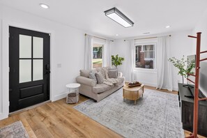A modern living room with a sofa, a coffee table, and a TV stand.