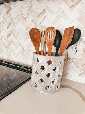 A kitchen utensil holder with wooden spoons and a black spatula. - Charming 2-bedroom house with WiFi, AC in Spartanburg (Spartanburg)