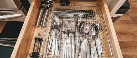Un cajón de cocina con utensilios de cocina ordenados en un organizador de alambre.