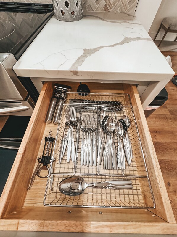 A kitchen drawer with utensils neatly organized in a wire rack. - Charming 2-bedroom house with WiFi, AC in Spartanburg (Spartanburg)