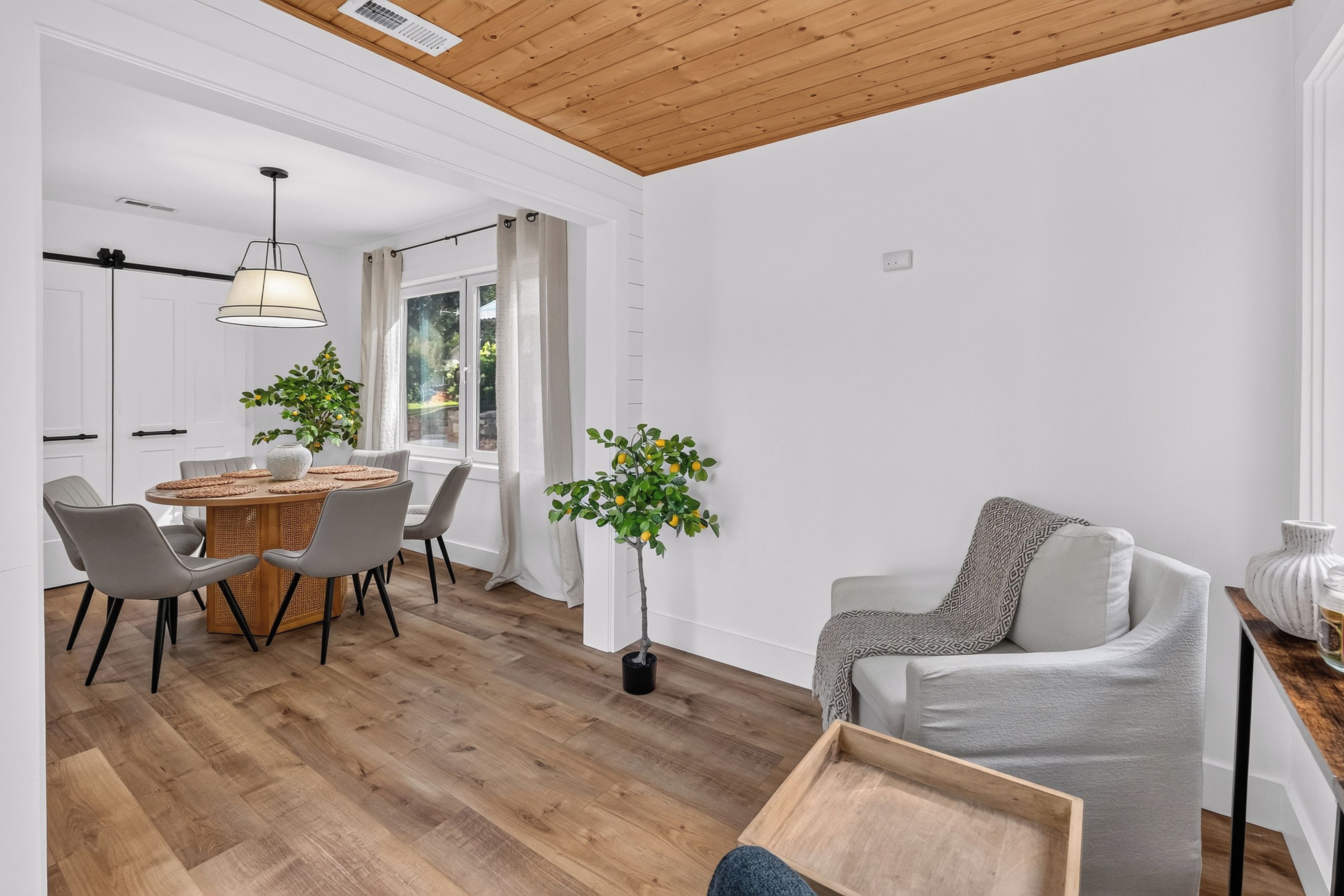 Un intérieur moderne comprenant un coin repas, un espace salon et un plafond en bois.