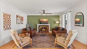 A living room with two sofas, a fireplace, and a ceiling fan. - Updated Spacious 4-bedroom house near Nob Hill and UNM.  (Albuquerque)