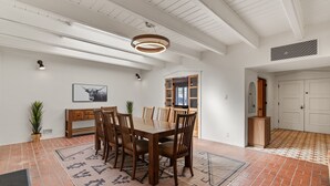 A dining area with a wooden table and chairs, a hanging light fixture, and a patterned rug. - Updated Spacious 4-bedroom house near Nob Hill and UNM.  (Albuquerque)