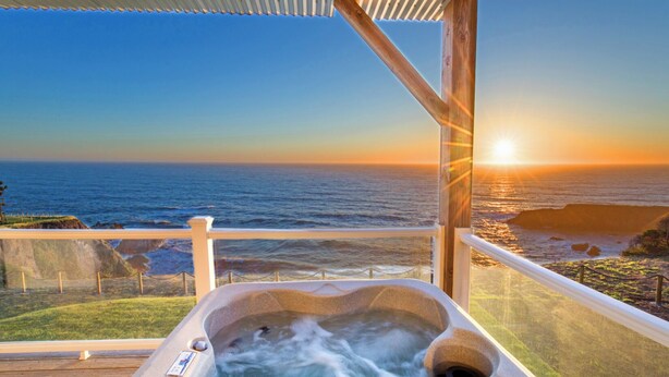 A hot tub on a deck overlooking the ocean at sunset. - Starfish by OceanviewHotTubs Oceanfront Tesla charging  Shelter Cove (Whitethorn)