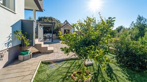 A modern house with a patio, a covered outdoor seating area, and a well-maintained garden. - Stunning apartment in Bibinje with WiFi (Bibinje)