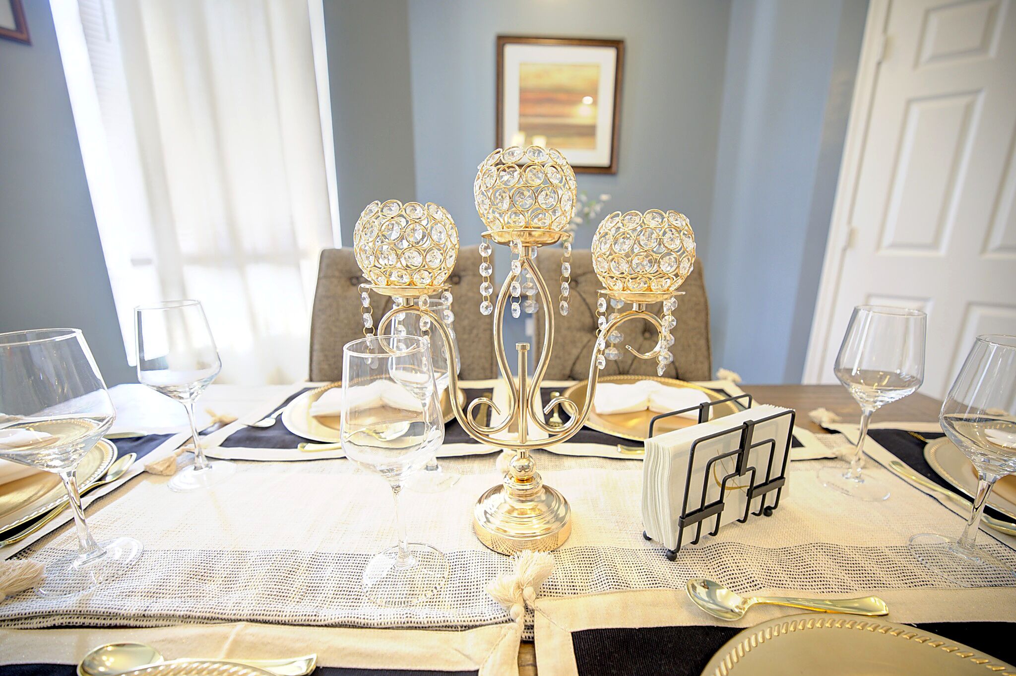 A dining table set with crystal candelabras, wine glasses, and silverware.