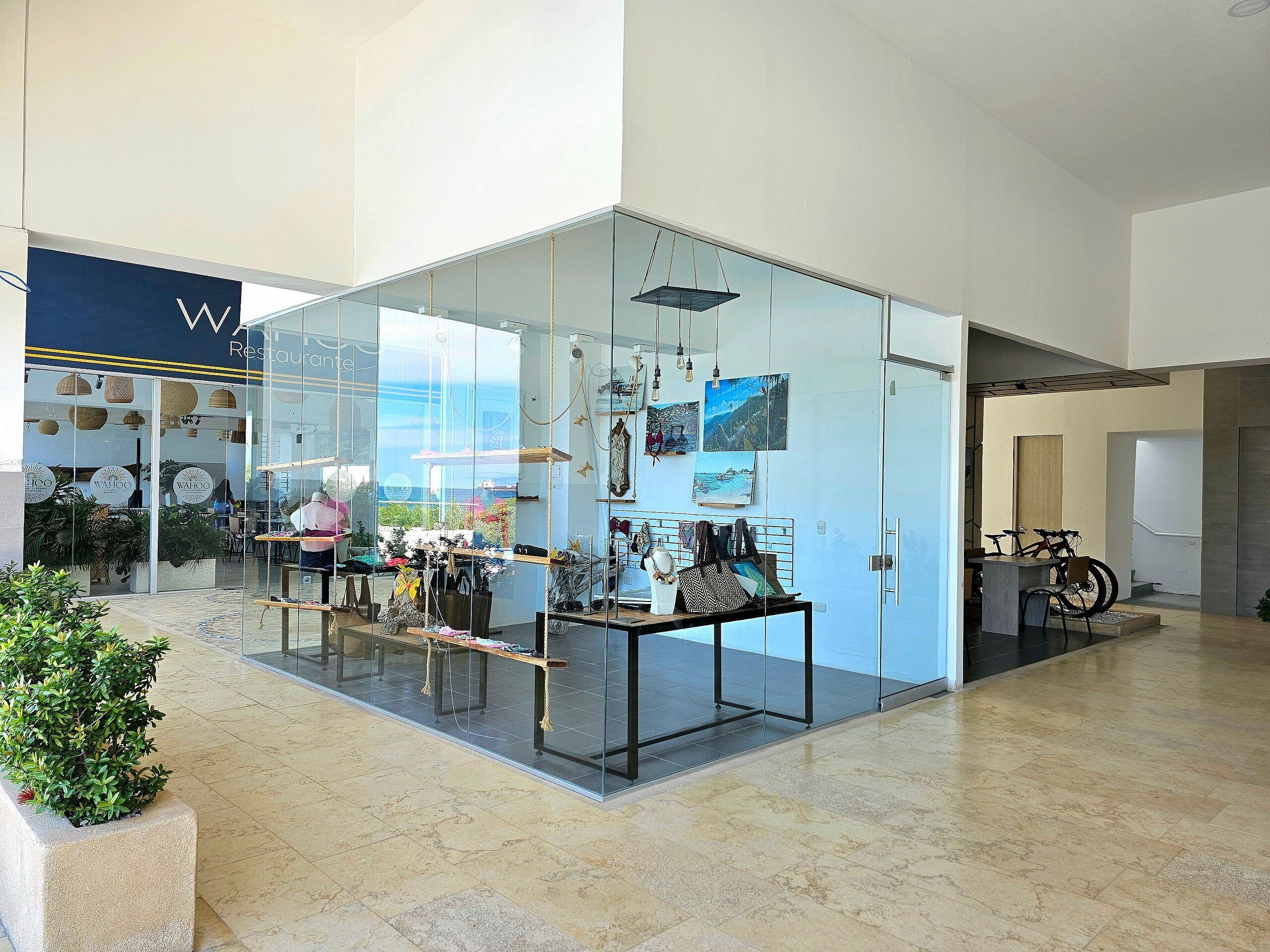 A modern interior with glass walls, a seating area, and a view of the outside.