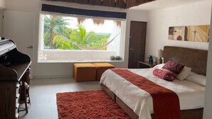 Ein Schlafzimmer mit Bett, Fenster mit Grünblick, Deckenventilator und einem Klavier.