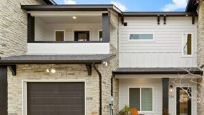 A two-story house with a garage, a balcony, and a front porch. - World Cup Stay in Arlington – Walk to AT&T Stadium (Arlington)
