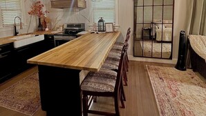 Een moderne keuken met een houten keukeneiland, inbouwapparatuur en een groot raam.