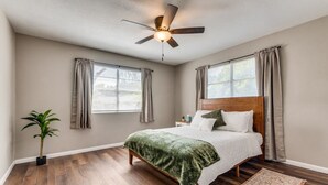 A bedroom with a bed, a ceiling fan, a potted plant, and a window with curtains. - Farm House with an Amazing Pool in the desirable Western Hills in Temple TX (Temple)