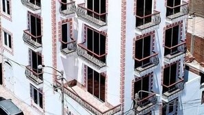 A multi-story building with balconies, a red-tiled roof, and a view of the ocean. - Blanca Rosa's Place (Pacasmayo)