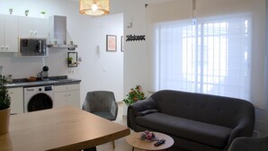 Ein moderner Wohnraum mit Küche, Essbereich und einer Couch.