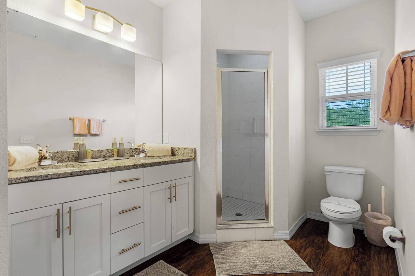 A bathroom with a shower, toilet, and sink with a vanity.