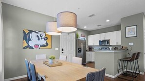 A modern kitchen with white cabinets, stainless steel appliances, and a central island.
