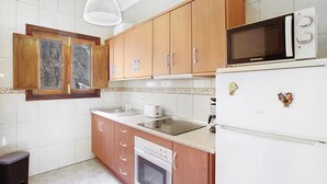 A kitchen with wooden cabinets, a microwave, a toaster, and a dishwasher.