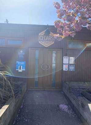En træbygning med et skilt, der viser 'CEDARS RESTAURANT & BAR' og et skilt med 'RØGFRIT'.