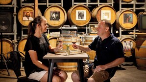 Two people seated at a table in a room with wooden barrels in the background. - BIG4 Red Cliffs Holiday Park (Red Cliffs)