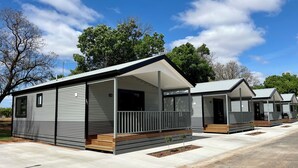 A row of modern, single-story mobile homes with a covered porch and a concrete driveway. - BIG4 Red Cliffs Holiday Park (Red Cliffs)