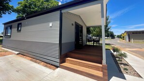 A modern mobile home with a covered porch and a small outdoor seating area. - BIG4 Red Cliffs Holiday Park (Red Cliffs)
