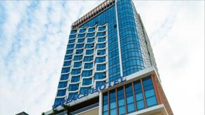 A hotel with a modern glass facade and a sign indicating it is a hotel. - Peace Hotel Ha Long (Bai Chay)