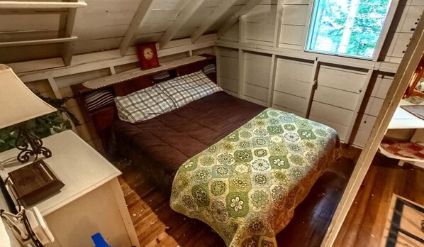 A compact room with a bed, a small table, and a window. - Private Island, 5 Homes, 2 HotTub, Boat -Sleeps 17 (Greig)