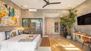 A modern bedroom with a large bed, a ceiling fan, a TV, and a large window. - Ubud Lila Concept (Ubud)