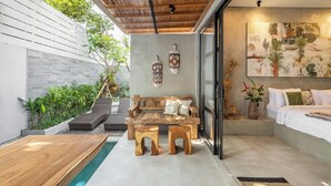 A modern interior with a wooden bench, a sofa, and a dining table. - Ubud Lila Concept (Ubud)