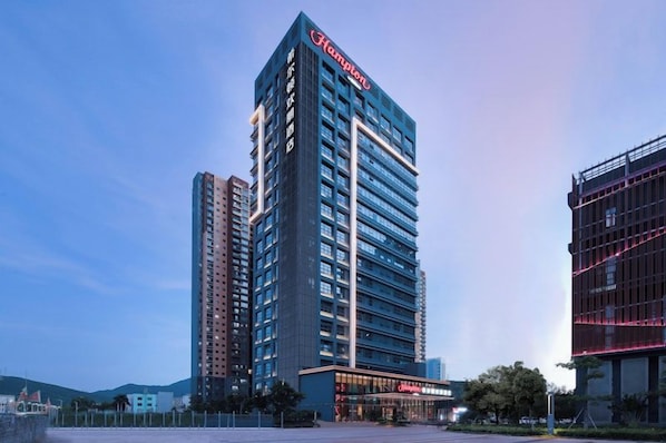 A high-rise hotel with a prominent 'Hotel' sign, multiple floors, and a modern architectural design. - Hampton BY Hilton Shenzhen Yuanshan (Shenzhen)