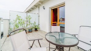 A balcony with a glass table, chairs, potted plants, and a sliding glass door. - Cozy 50 sqm apartment for 3 people, located on the sixth floor with an elevator (not suitable for people with disabilities). Just 100 meters from the Carducci Metro station, the apartment features a large terrace. Located in a well-served area of Turin,  (Torino)