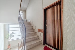 A staircase with a wooden handrail, a potted plant, and a red mat at the base. - Cozy 50 sqm apartment for 3 people, located on the sixth floor with an elevator (not suitable for people with disabilities). Just 100 meters from the Carducci Metro station, the apartment features a large terrace. Located in a well-served area of Turin,  (Torino)