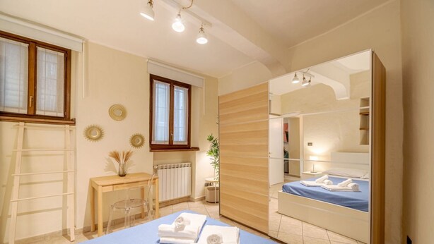 A bedroom with a bed, a desk, a chair, a radiator, and a mirror. - GuestHost - Comfortable apartment, able to accommodate up to 4 people. The accommodation is located in a refined period building in the center of Turin, a few meters from Piazza Castello and the Royal Palace, a short distance from every essential service (Torino)