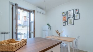 A kitchen with a wooden countertop, a refrigerator, a dining table with chairs, and a window with a view of buildings. - GuestHost - Comfortable apartment, able to accommodate up to 4 people. The accommodation is located in a refined period building in the center of Turin, a few meters from Piazza Castello and the Royal Palace, a short distance from every essential service (Torino)