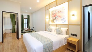 A hotel room with a large bed, a bedside table, a wall-mounted artwork, and a sliding door. - Collection O Samurai Hotel (Denpasar)