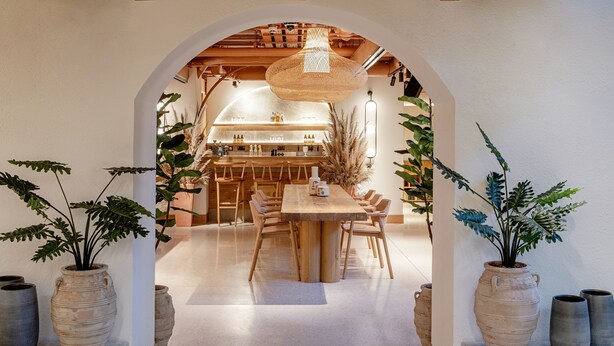 Una cucina moderna con mobili in legno, un'isola centrale e una lampada a sospensione.