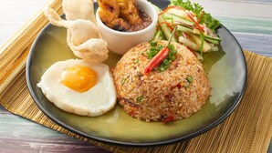 A plate with fried rice, a fried egg, fried chicken skewers, and a side salad. - Scapes Hotel (Genting Highlands)