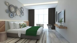 A modern hotel room with a large bed, a side table, a chair, a TV, and a window with curtains. - Scapes Hotel (Genting Highlands)