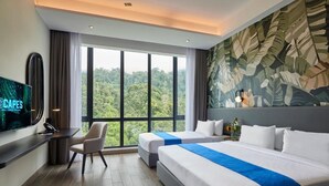 Habitación de hotel con dos camas, un escritorio, un televisor y un ventanal con vistas a un bosque.