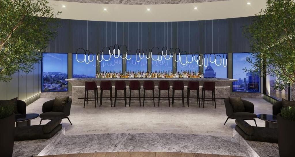 A bar area with a long counter, multiple bar stools, and a large window with a cityscape view.